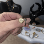 Close-up detail of the Alora adjustable pearl fidget ring with gold frame and stone.