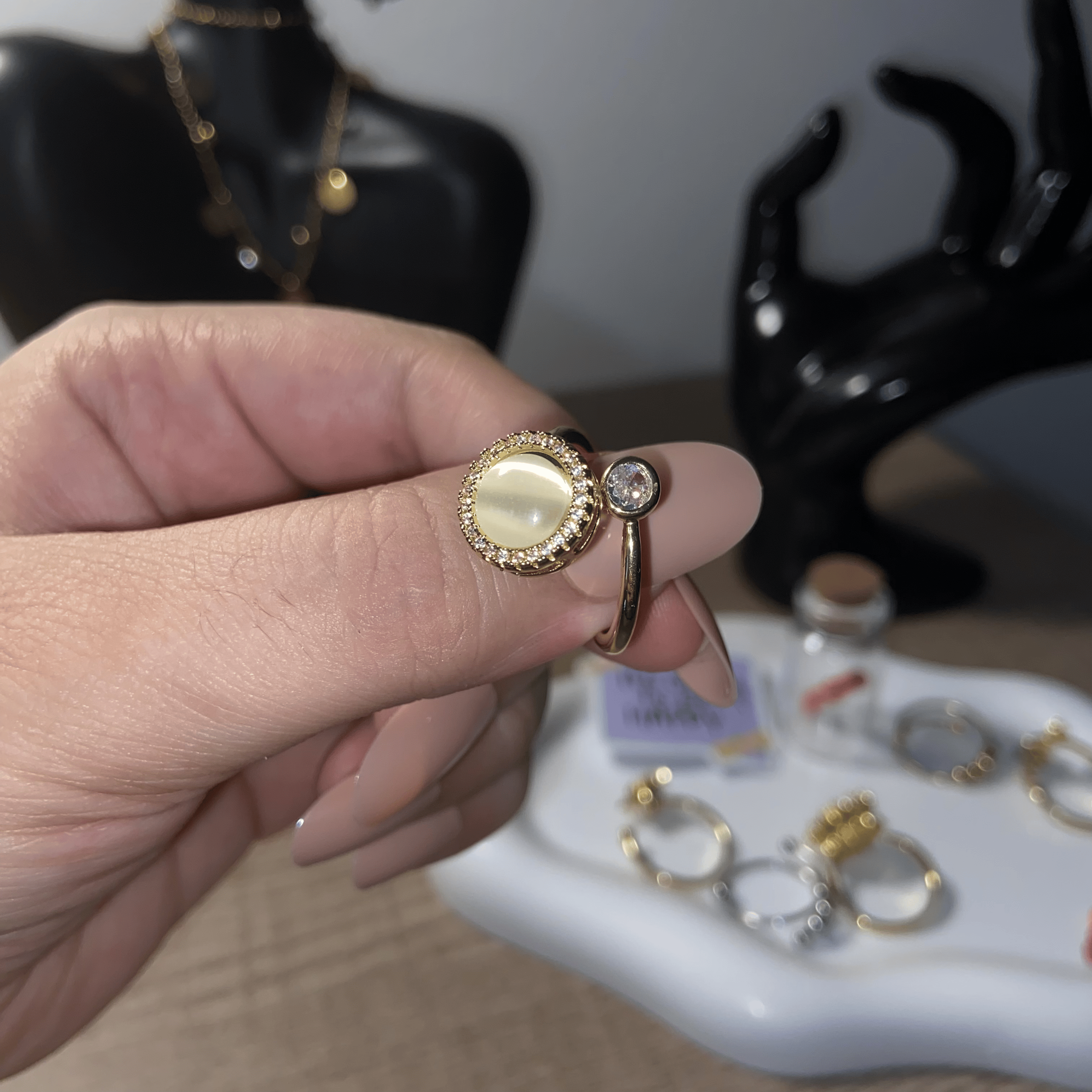 Close-up detail of the Alora adjustable pearl fidget ring with gold frame and stone.